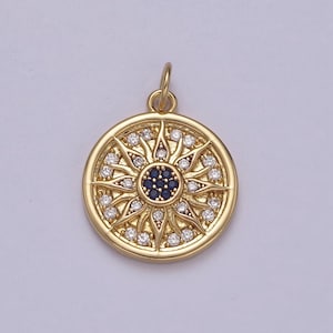 May include: A gold-toned pendant featuring a sun design with a blue center and clear crystals around the edges.