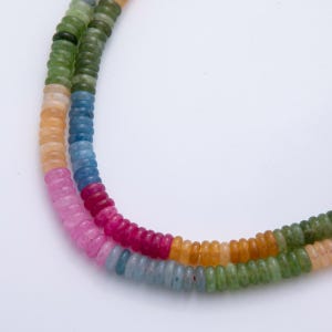 Peut inclure: Deux rangées de perles de pierres précieuses colorées. Les perles rondes et petites sont de différentes couleurs, notamment rose, rouge, bleu, vert et jaune. Les rangées incurvées semblent être faites de pierres naturelles.