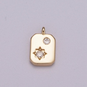 Puede incluir: Charme de colgante de oro con forma rectangular y dos pequeños diamantes transparentes. Un diamante está engastado en forma de estrella y el otro en forma de círculo.