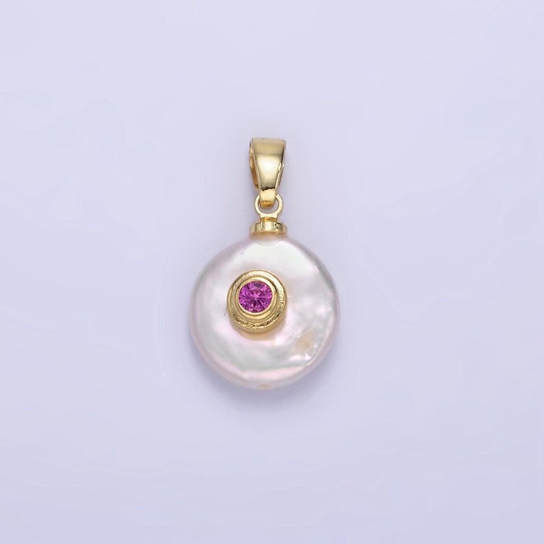 May include: A gold pendant featuring a white pearl with a pink gemstone set in a gold bezel.