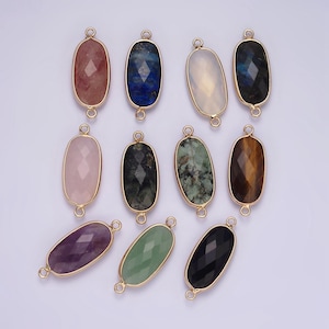 Puede incluir: Surtido de 10 dijes ovalados de piedra preciosa con detalles en metal dorado. Las piedras incluyen amatista, cuarzo rosa, aventurina verde, ónix negro, ojo de tigre, labradorita, lapislázuli, cuarzo transparente y dos tonos de verde.