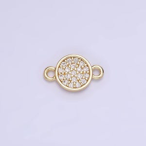 May include: Gold-toned connector with a round, pave-set crystal design. The connector has two loops for attaching jewelry.