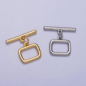 May include: Two toggle clasps, one gold and one silver, with a rectangular loop and a bar. The clasps are used for jewelry making.