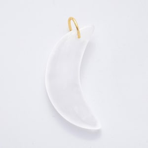 Op de afbeelding: Een maanvormige hanger van doorschijnend wit materiaal, met een goudkleurige lus aan de bovenkant. De hanger is glad en gebogen, tegen een witte achtergrond.