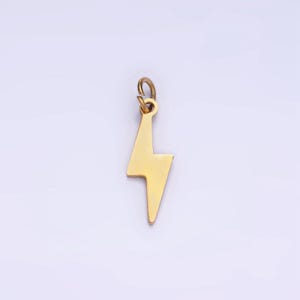 May include: A gold-colored lightning bolt charm pendant. The pendant has a loop at the top for attaching to a chain or bracelet.