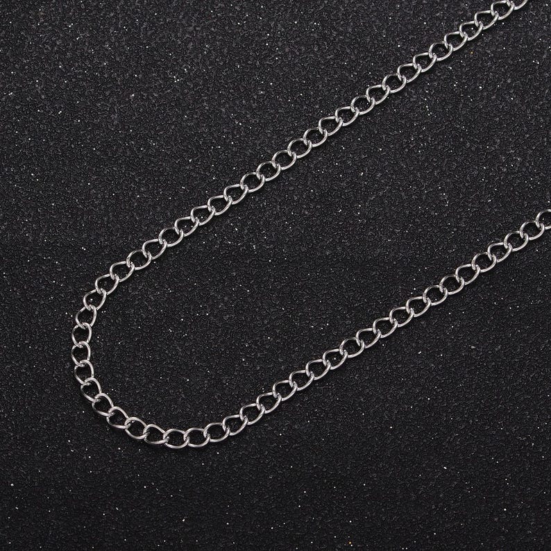 May include: A silver chain necklace with a simple, classic design. The chain is made of small, linked circles.