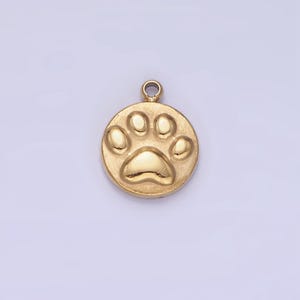 May include: Gold-toned metal charm in the shape of a paw print. The charm is round and has a raised paw print design.