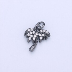 May include: A black palm tree charm with clear crystal accents. The charm has a loop at the top for attaching to a bracelet or necklace.