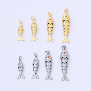 May include: A collection of gold and silver fish-shaped charms. The charms have detailed scales, fins, and eye accents. The gold charms have a warm, shiny finish, while the silver charms have a cool, metallic appearance. These charms are suitable for jewelry making.