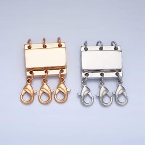 May include: Two sets of three gold and silver metal clasps with three swivel lobster clasps attached to each. The clasps are rectangular with a smooth surface.