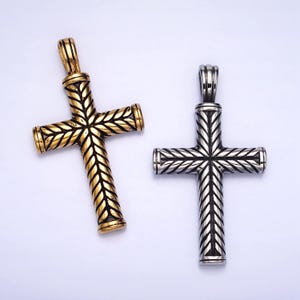 May include: Two silver and gold cross pendants with a braided design. The crosses are both the same size and shape.