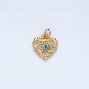 以下が含まれることがあります： クリアなラインストーンで囲まれた青とターコイズの邪悪な目をモチーフにした、ゴールドのハート型のペンダント。