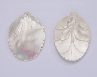 May include: Two white mother of pearl shell pendants, one with a smooth surface and the other with a carved design. Both pendants have a hole at the top for hanging.