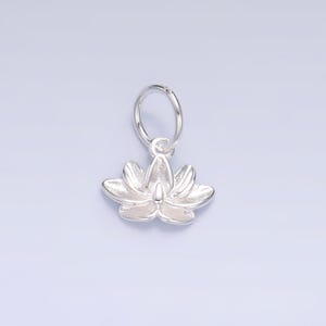 Op de afbeelding: Een zilveren bedel in de vorm van een lotusbloem met een springring.