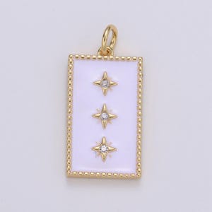 May include: Gold pendant charm with a white enamel rectangle featuring three gold stars with clear rhinestones. The charm has a gold loop for attaching to a necklace or bracelet.