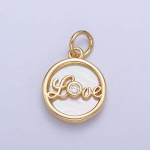 May include: Gold-tone pendant with a round, white mother-of-pearl inlay featuring the word "Love" in a cursive script with a small, clear rhinestone in the center.