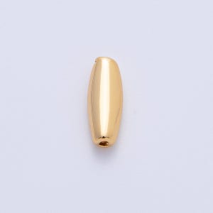 May include: A single, elongated gold-colored bead with a smooth, polished surface. The bead has a rounded, oblong shape with a small hole at one end, suggesting it is designed for stringing or jewelry making.