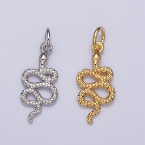 Peut inclure: Deux pendentifs en forme de serpent, l'un en argent et l'autre en or. Les deux pendentifs présentent un design de serpent détaillé avec une surface texturée.