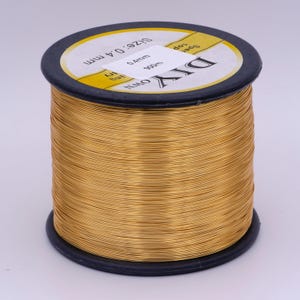 Pu&ograve; includere: Un rotolo di filo color oro, etichettato "DIY OWN" e "Size 0.4mm 900m".
