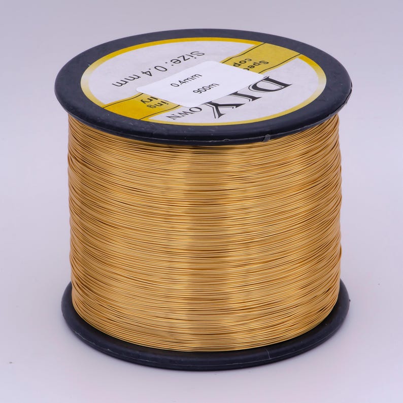 Pu&ograve; includere: Un rotolo di filo color oro, etichettato "DIY OWN" e "Size 0.4mm 900m".