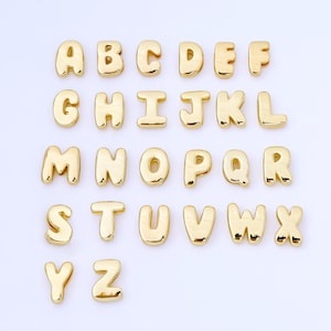 May include: A set of gold-coloured alphabet letter charms, each with a rounded, bubble-like design. The letters A to Z are displayed, ideal for personalised jewellery or craft projects. The letters are arranged in rows on a white background.