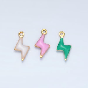 May include: Three gold-tone lightning bolt charms with enamel accents. The charms are pink, white, and green.