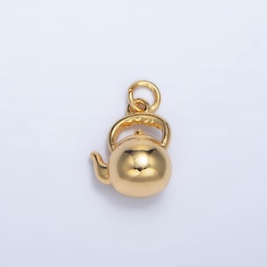 May include: A gold-colored teapot charm with a loop for attaching to a necklace or bracelet.