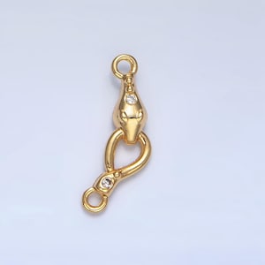 May include: Gold-toned snake-shaped connector with clear crystal accents. The connector has two loops for attaching jewellery pieces.