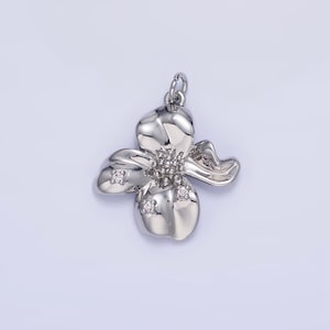 May include: Silver flower pendant with clear cubic zirconia stones.