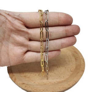 May include: Two gold and silver chain necklaces with a paperclip link design.
