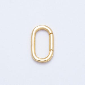 May include: A gold-colored oval-shaped clasp, featuring a hinged design for secure closure. The clasp is made of a shiny, metallic material and is set against a plain white background. This jewelry finding is suitable for various crafting projects.