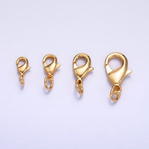 May include: Four gold-toned lobster claw clasps of varying sizes. The clasps are commonly used for jewelry making.