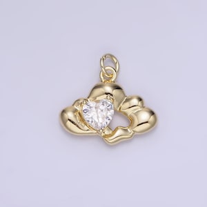 Puede incluir: Encanto de colgante de tono dorado con un diseño de nube y un cristal transparente en forma de corazón en el centro.