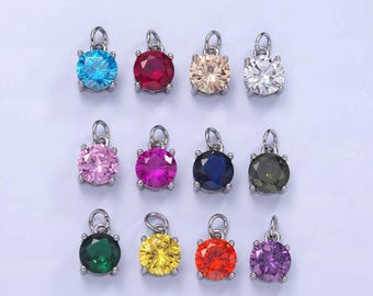 May include: Twelve round, silver-toned charms with colourful rhinestones. Each charm features a different colour rhinestone, including blue, red, beige, white, pink, fuchsia, dark blue, green, emerald green, yellow, orange, and purple.