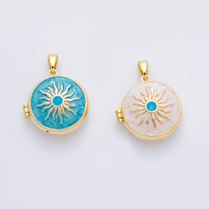 May include: Two gold-colored, round pendants with a sunburst design. One pendant has a turquoise background, the other a white background. Both have a gold frame and a small blue center.