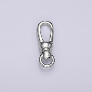 May include: Silver swivel clasp with a round ring. This clasp is used for attaching jewelry, bags, or other accessories.