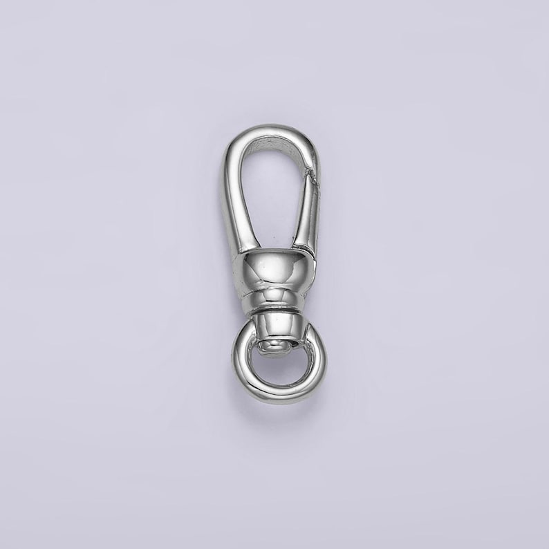 May include: Silver swivel clasp with a round ring. This clasp is used for attaching jewelry, bags, or other accessories.