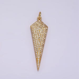 May include: Gold pendant with a geometric, pointed shape, fully covered in small, clear rhinestones.