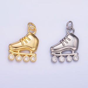May include: Two roller skate charms, one gold and one silver, with clear rhinestone accents.
