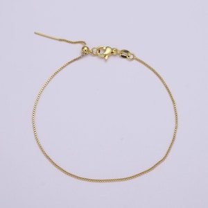 May include: A gold chain bracelet with an adjustable sliding clasp.