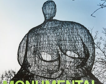 May include: A black and white poster with green text that reads "Monumental" and "Sculpture and Architecture in the work of Niki de Saint Phalle". The poster also includes the text "Espace Jean Tinguely Niki de Saint Phalle Fribourg" in white text. The poster features a black and white image of a large wire sculpture of a person.