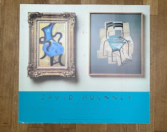 May include: A poster advertising a David Hockney retrospective at The Metropolitan Museum of Art in New York City. The poster features two images of chairs, one in a blue and white pattern and the other in a black and white pattern. The text on the poster reads "David Hockney, A Retrospective, The Metropolitan Museum of Art, N.Y., June 19 - Aug 14, 1998."