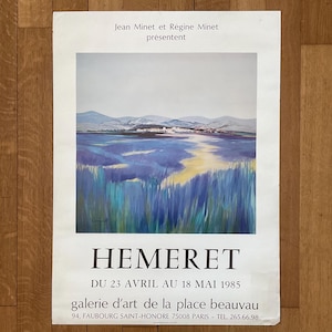 May include: A vintage poster advertising an art exhibition by Hemeret. The poster features a painting of a landscape with a village in the distance and a field of purple flowers in the foreground. The text on the poster reads "Jean Minet et Régine Minet présentent Hemeret Du 23 Avril au 18 Mai 1985 galerie d'art de la place beauvau 94, Faubourg Saint-Honoré 75008 Paris Tel. 265.66.98"