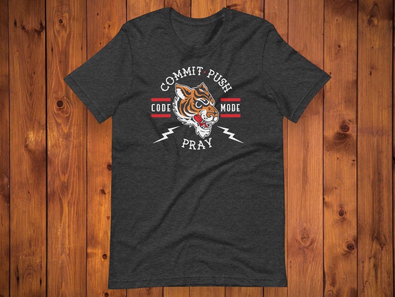 K&ouml;nnte beinhalten: Ein dunkelgraues T-Shirt mit einem Tiger-Motiv und dem Text "Commit Push Code Pray Mode".