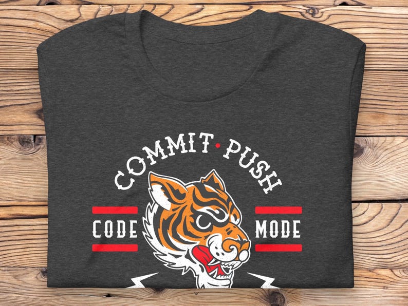 K&ouml;nnte beinhalten: Dunkelgraues T-Shirt mit einem wei&szlig;en Grafikdruck eines Tigers mit dem Text "COMMIT PUSH CODE MODE" drumherum.