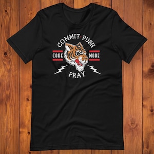 Könnte beinhalten: Schwarzes T-Shirt mit einem Tigerkopf-Motiv und dem Text "Commit Push Code Pray Mode".