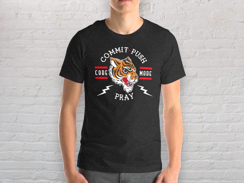 K&ouml;nnte beinhalten: Ein dunkelgraues T-Shirt mit einem Tiger-Motiv und dem Text "Commit Push Code Pray Mode".