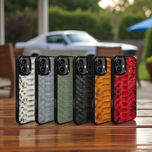 Pode incluir: Seis capas de smartphone alinhadas, com um padrão de pele de cobra texturizada nas cores branco, cinza, verde, preto, laranja e vermelho. Cada capa tem uma borda preta e um recorte para a câmera.