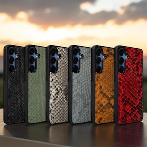 May include: Six rectangular smartphone cases arranged in a row, each featuring a textured snakeskin pattern in black, olive green, white, grey, brown, and red. Each case has a black frame and a vertical camera cutout on the upper left side.