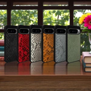 Pode incluir: Seis capas de telefone com um padrão de pele de cobra texturizado em preto, vermelho, branco, laranja, cinza e verde. Cada capa tem uma borda preta e um recorte para a câmera.